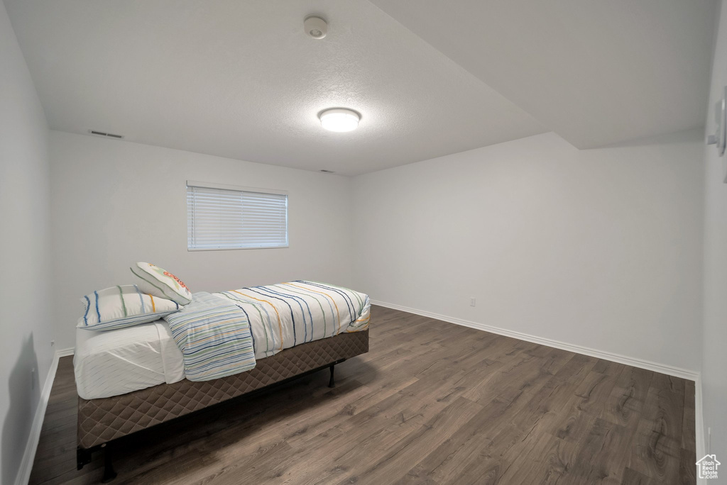 Bedroom with baseboards and dark wood-style floors