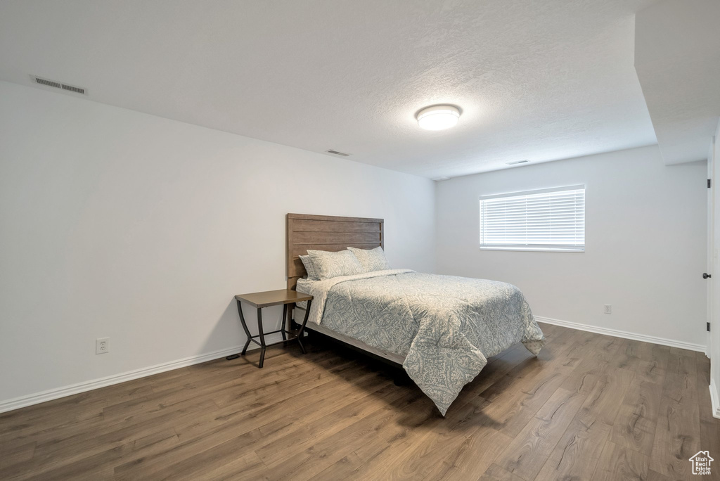 Bedroom featuring wood finished floors and a textured ceiling