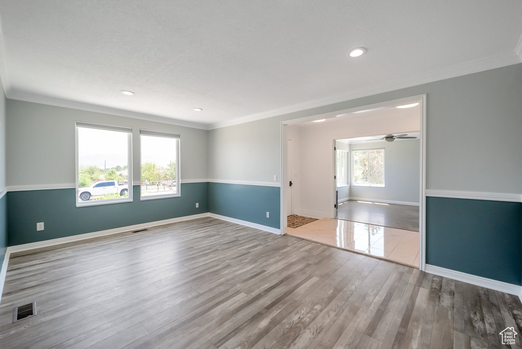 Empty room featuring wood finished floors, ornamental molding, a ceiling fan, and recessed lighting