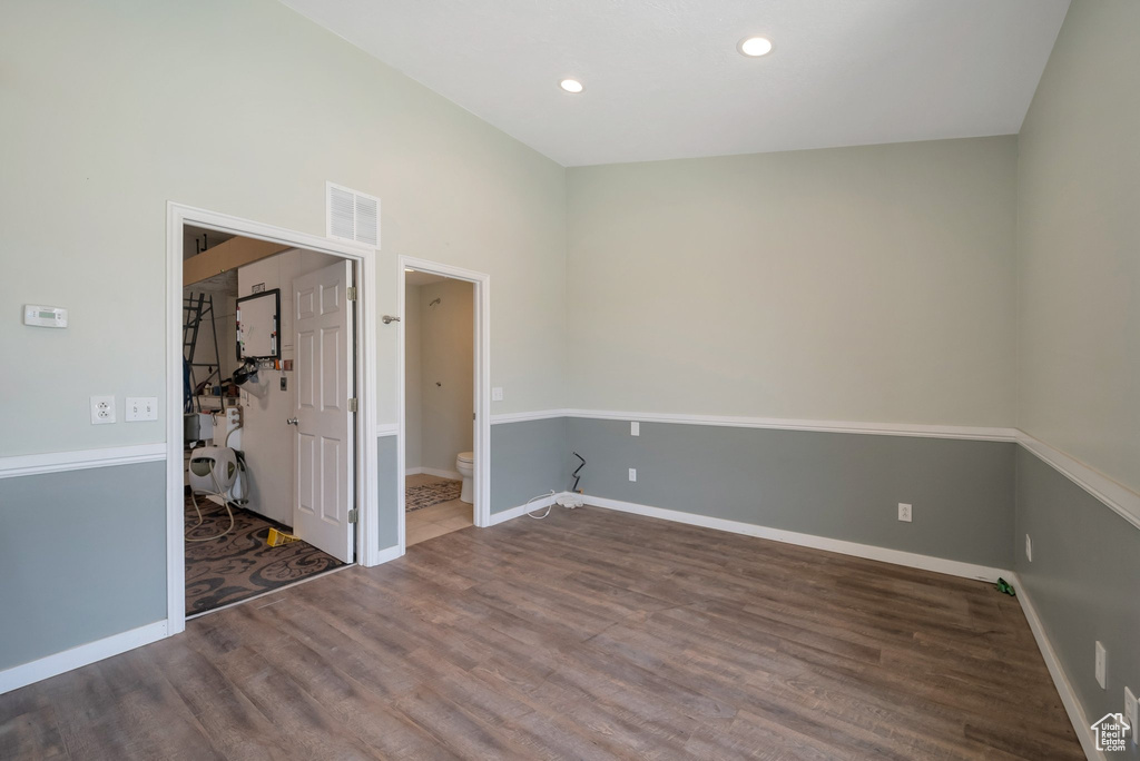 Unfurnished bedroom with wood finished floors, recessed lighting, and ensuite bath