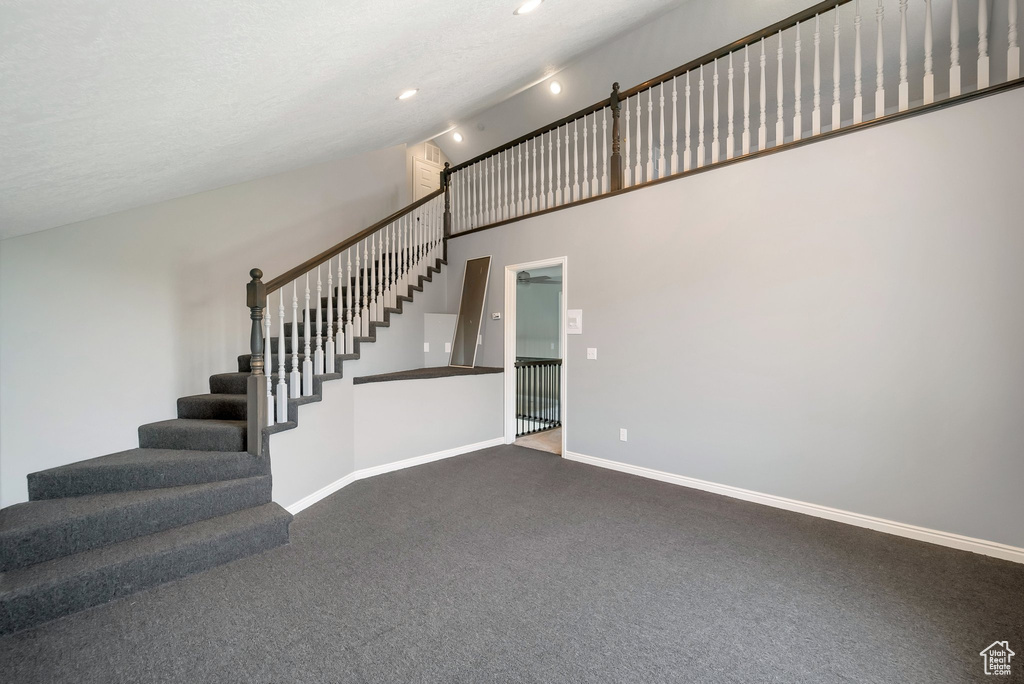 Staircase featuring carpet, high vaulted ceiling, and recessed lighting