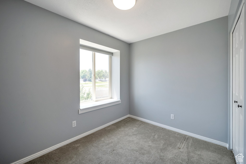 Carpeted empty room with baseboards