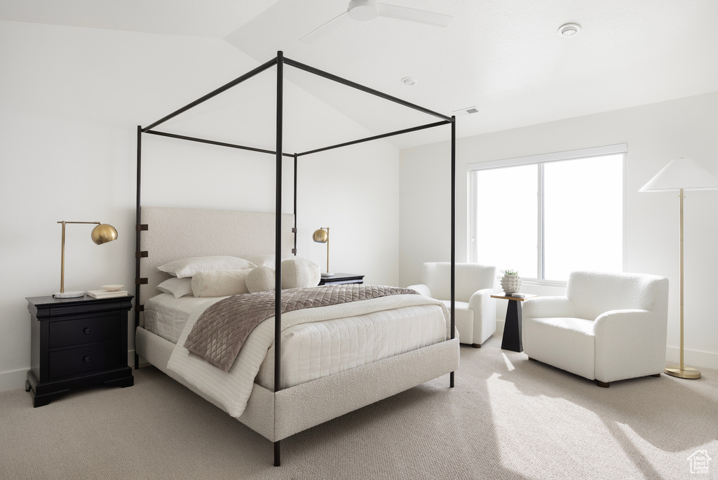 Bedroom with light carpet, ceiling fan, and vaulted ceiling