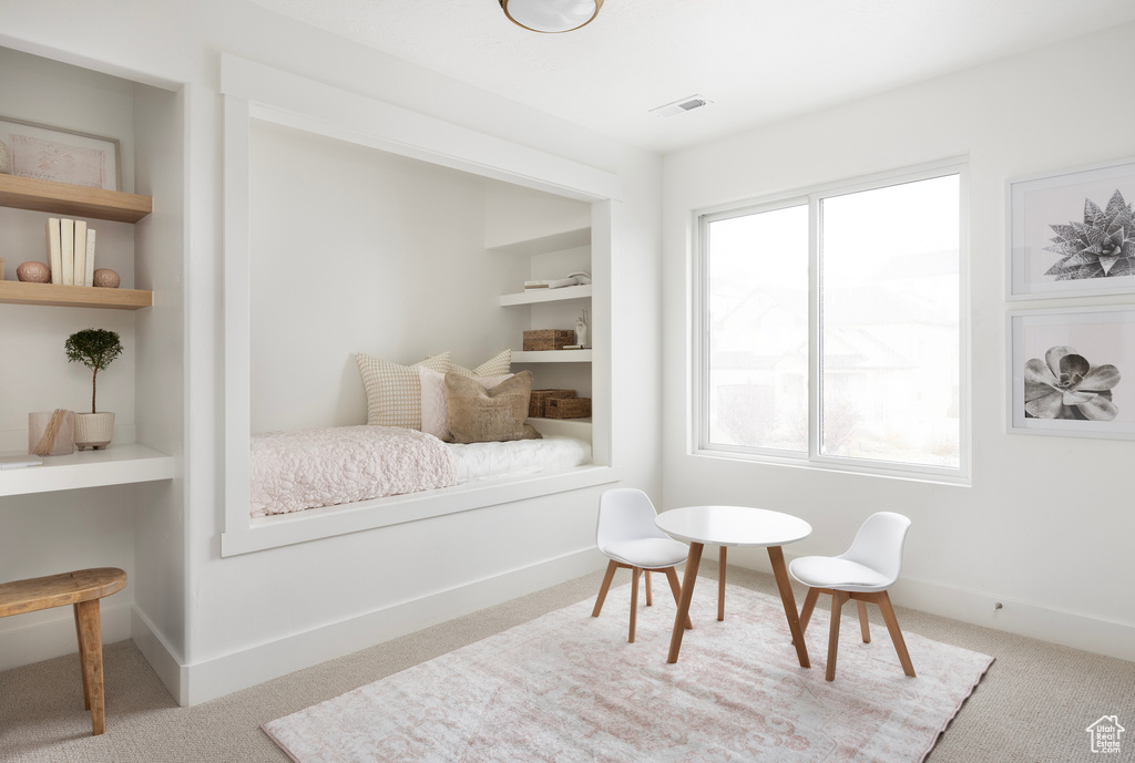 Sitting room with carpet flooring and built in shelves