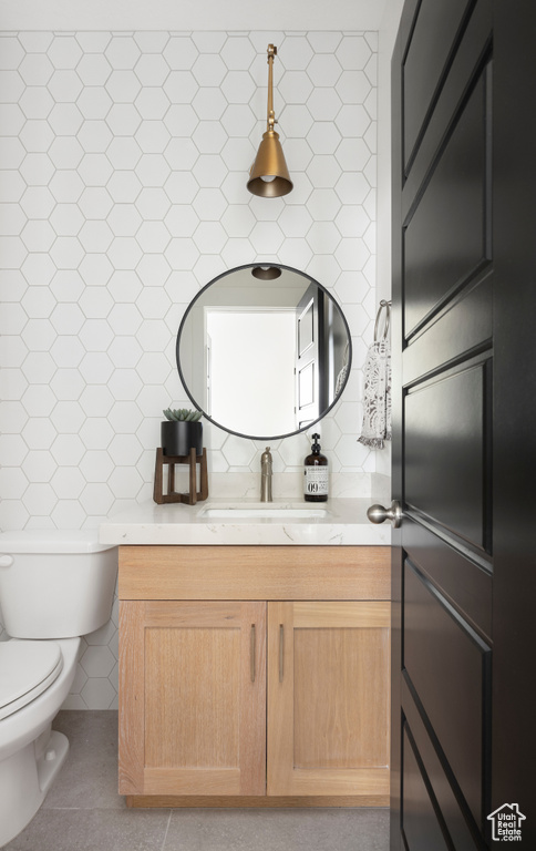 Bathroom with vanity, tile patterned flooring, tasteful backsplash, and tile walls