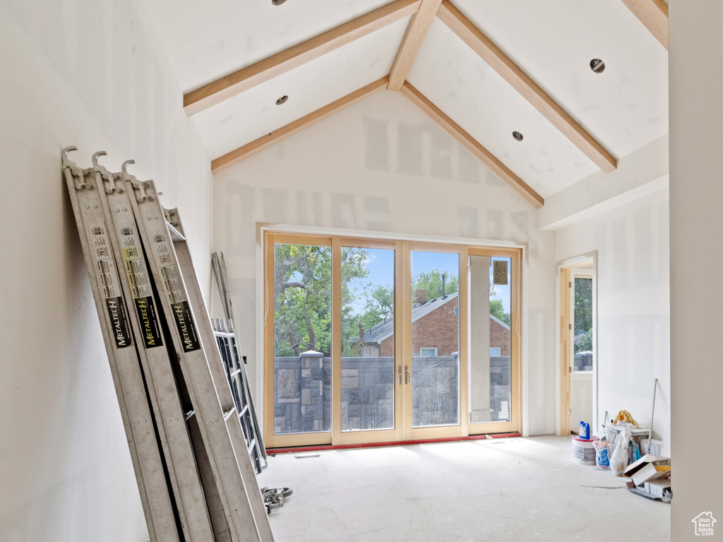 Doorway to outside with beamed ceiling, high vaulted ceiling, and french doors