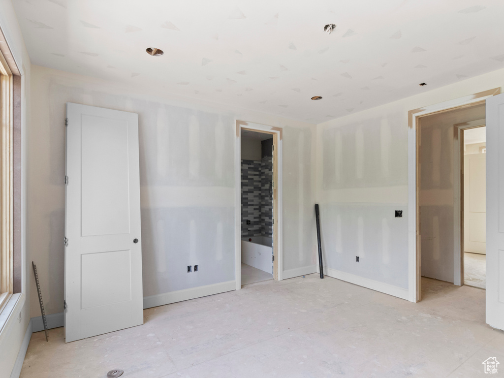 Unfurnished bedroom with baseboards and ensuite bath