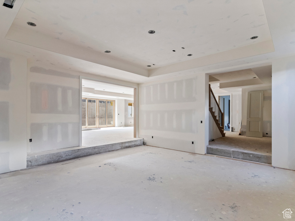 Unfurnished room with a raised ceiling and stairway