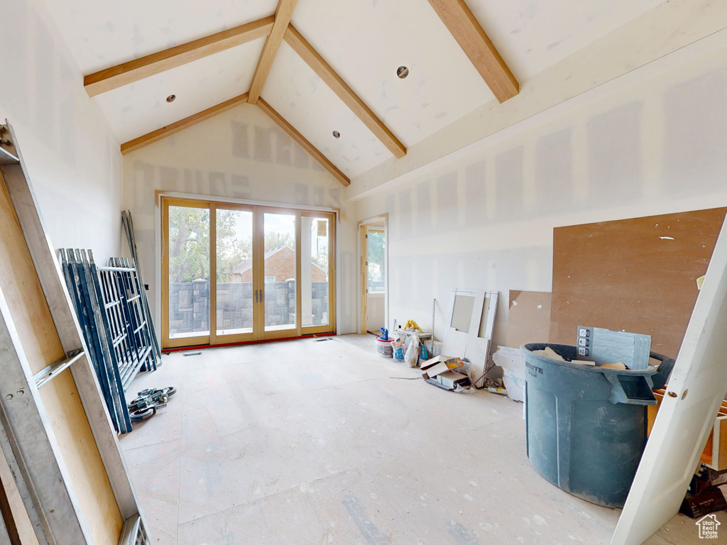 Living area with high vaulted ceiling and beam ceiling