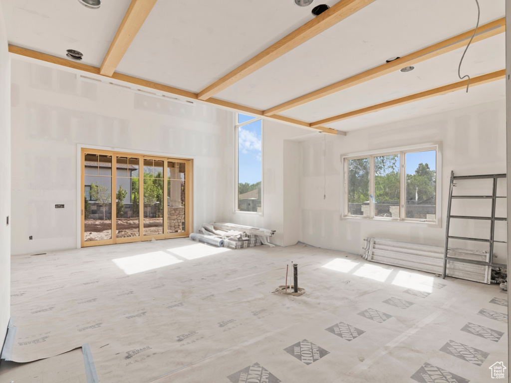 Unfurnished living room featuring beam ceiling