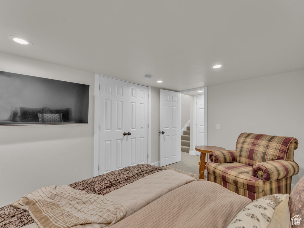 Bedroom with recessed lighting, light colored carpet, and a closet
