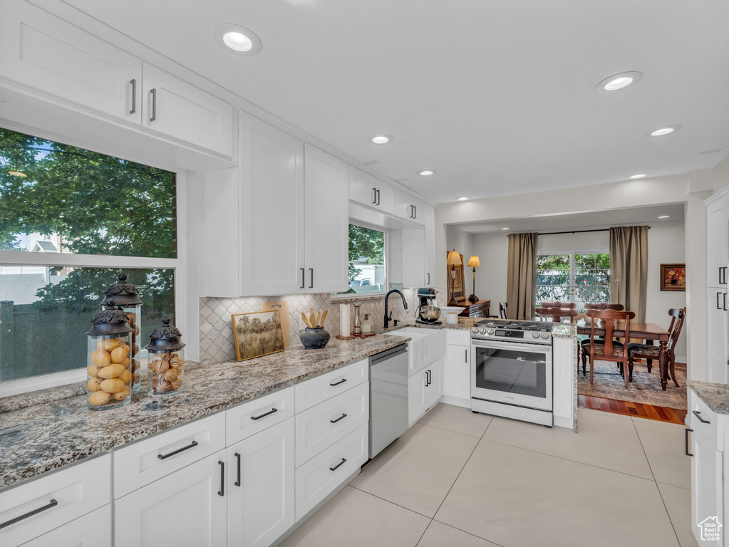 Kitchen featuring appliances with stainless steel finishes, white cabinetry, healthy amount of natural light, and recessed lighting