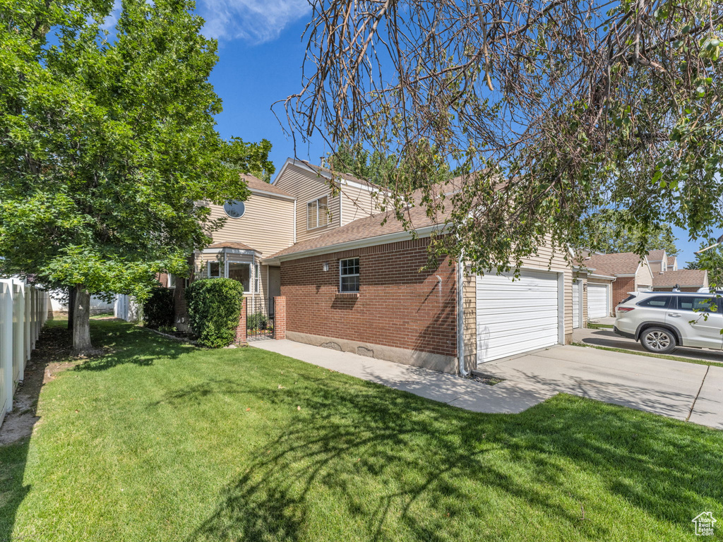 View of side of home featuring brick siding, driveway, an attached garage, and a shingled roof