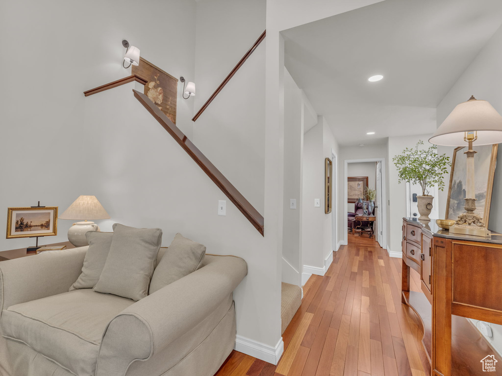 Living area featuring light wood-type flooring, recessed lighting, and stairway