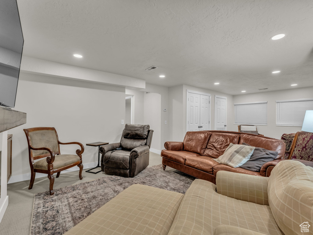 Living room featuring carpet flooring, recessed lighting, and a textured ceiling