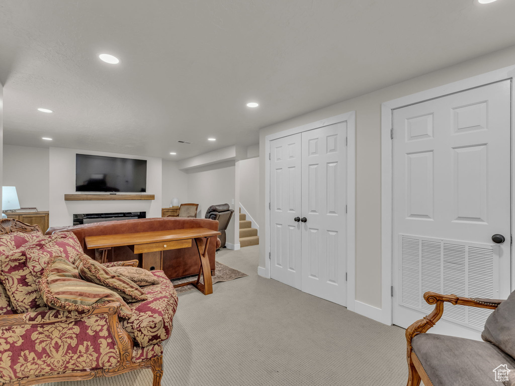 Living area with light carpet, recessed lighting, a fireplace, and stairway