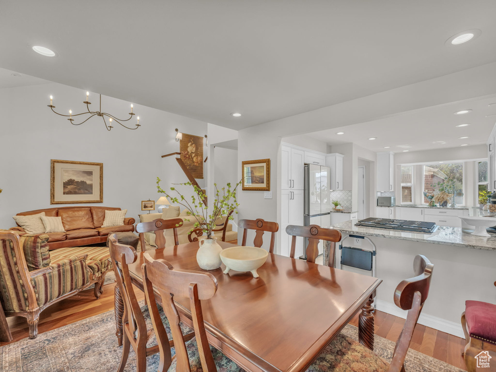 Dining space with light wood-style floors, a chandelier, and recessed lighting