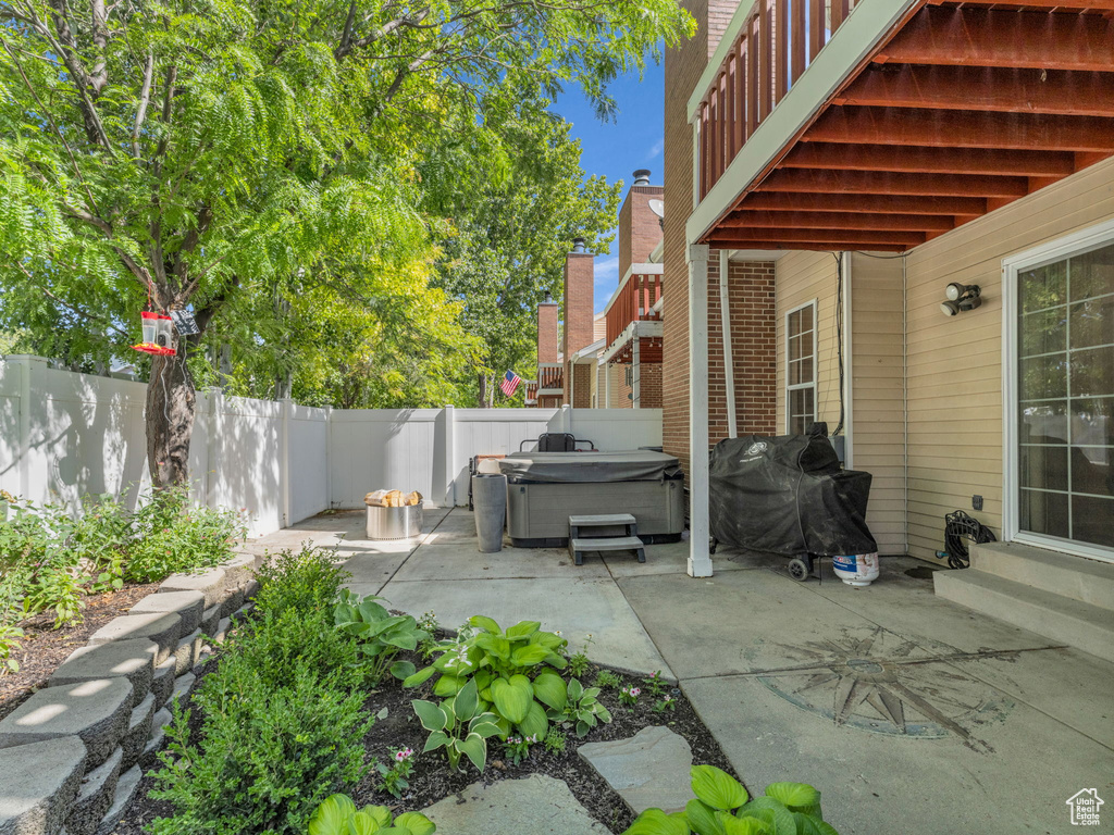 Fenced backyard with a hot tub, a patio, and area for grilling