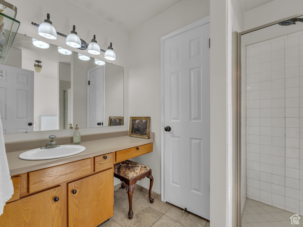 Full bath with a shower stall, tile patterned floors, and vanity