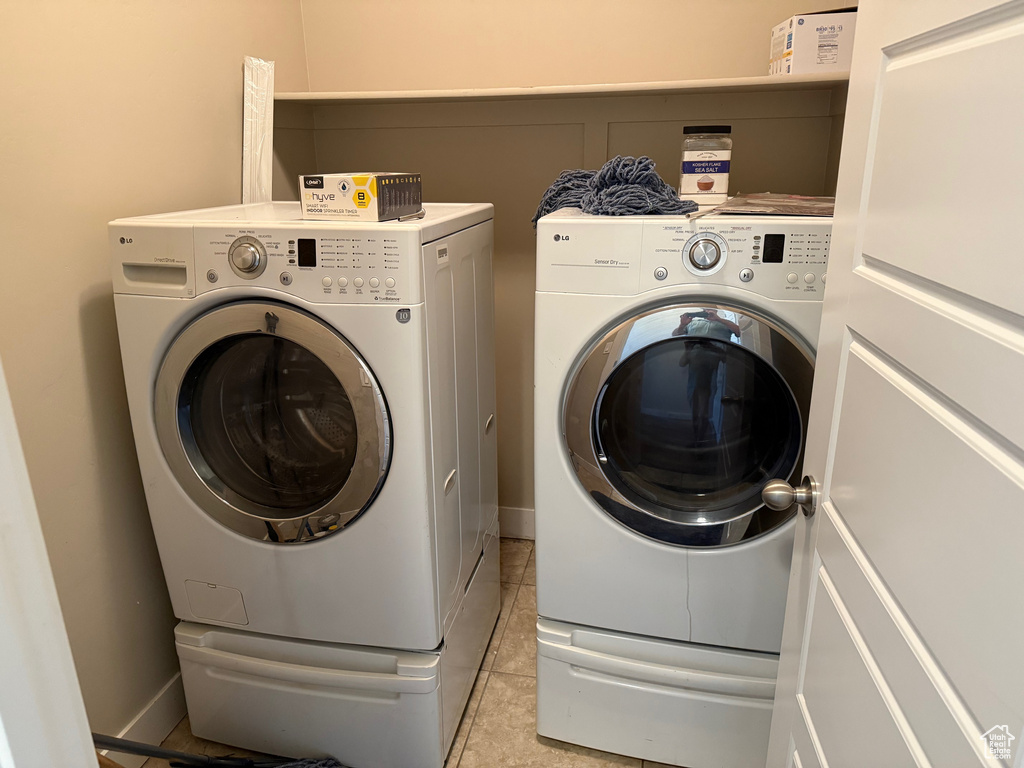 Laundry area featuring washer and dryer and light tile patterned floors