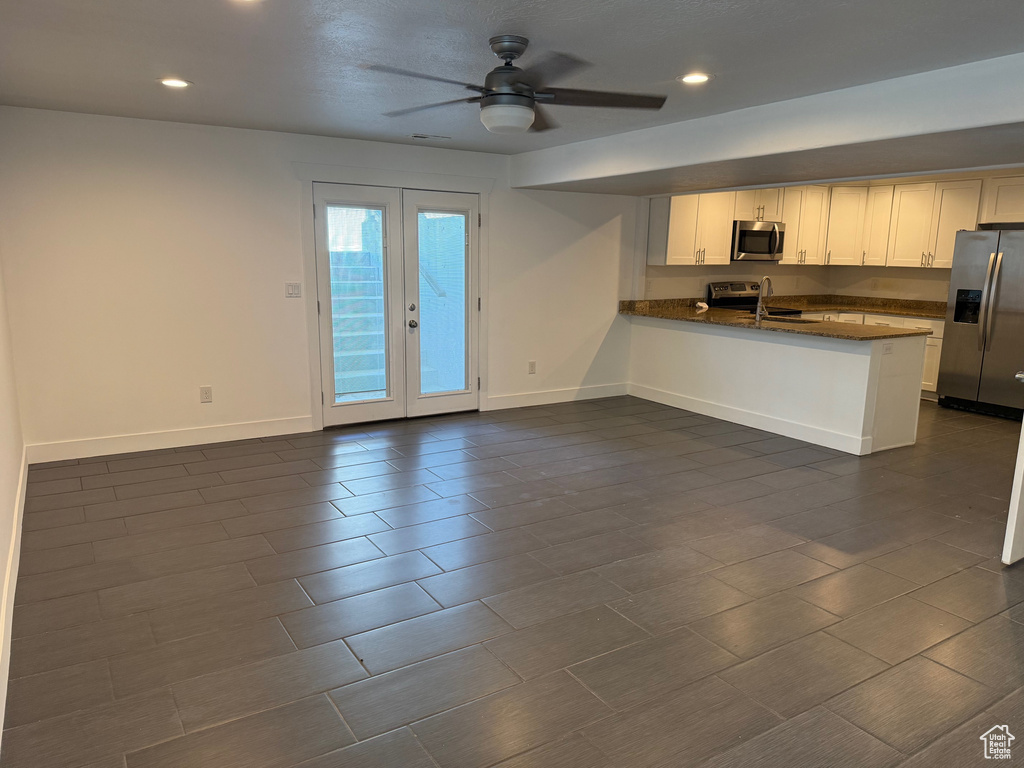 Kitchen featuring appliances with stainless steel finishes, a peninsula, a ceiling fan, recessed lighting, and white cabinetry