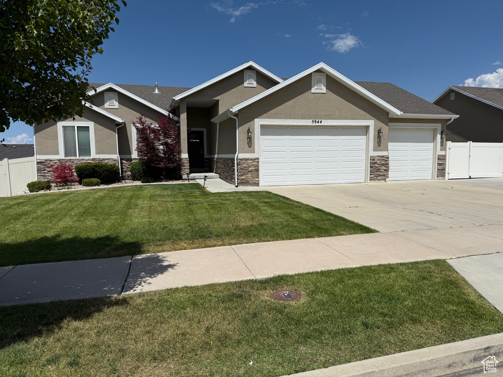 Craftsman house featuring stone siding, driveway, an attached garage, and stucco siding