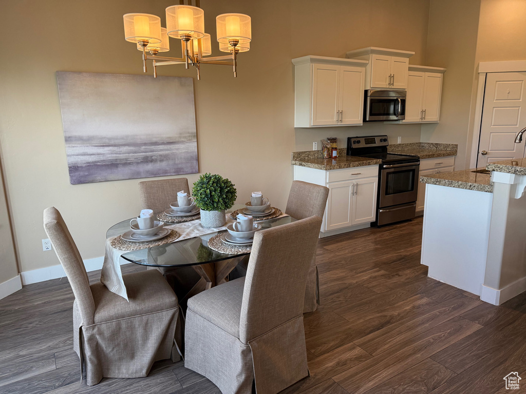 Dining area featuring dark wood finished floors and a chandelier
