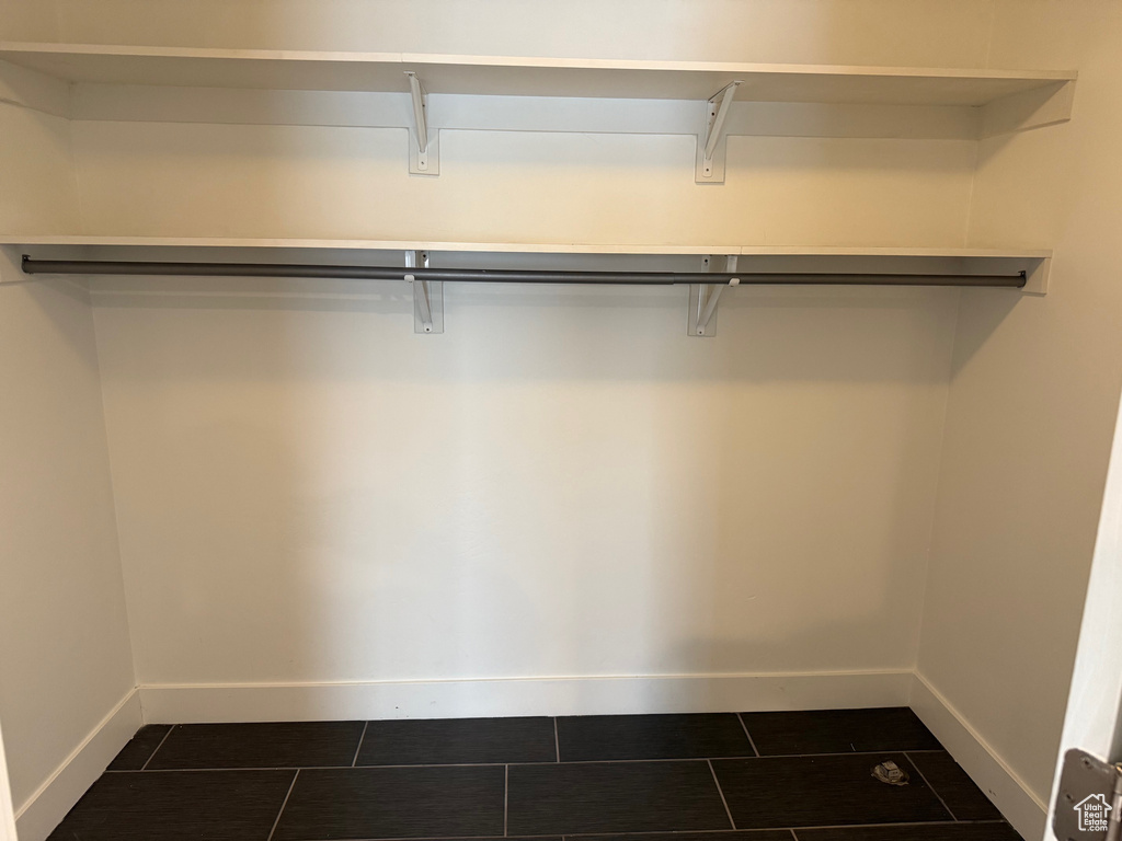 Walk in closet featuring dark tile patterned flooring