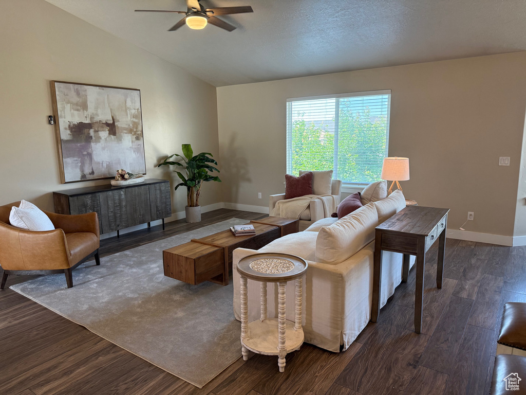 Living area with ceiling fan, dark wood-type flooring, and vaulted ceiling
