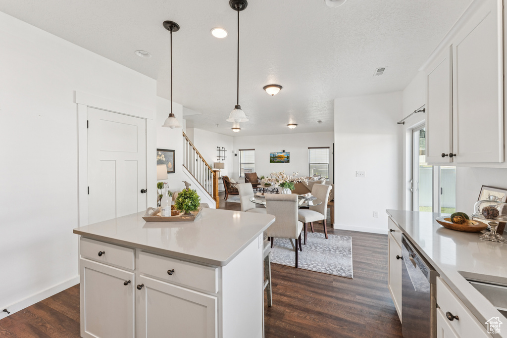 Kitchen with dishwasher, dark wood-style floors, light countertops, white cabinets, and recessed lighting