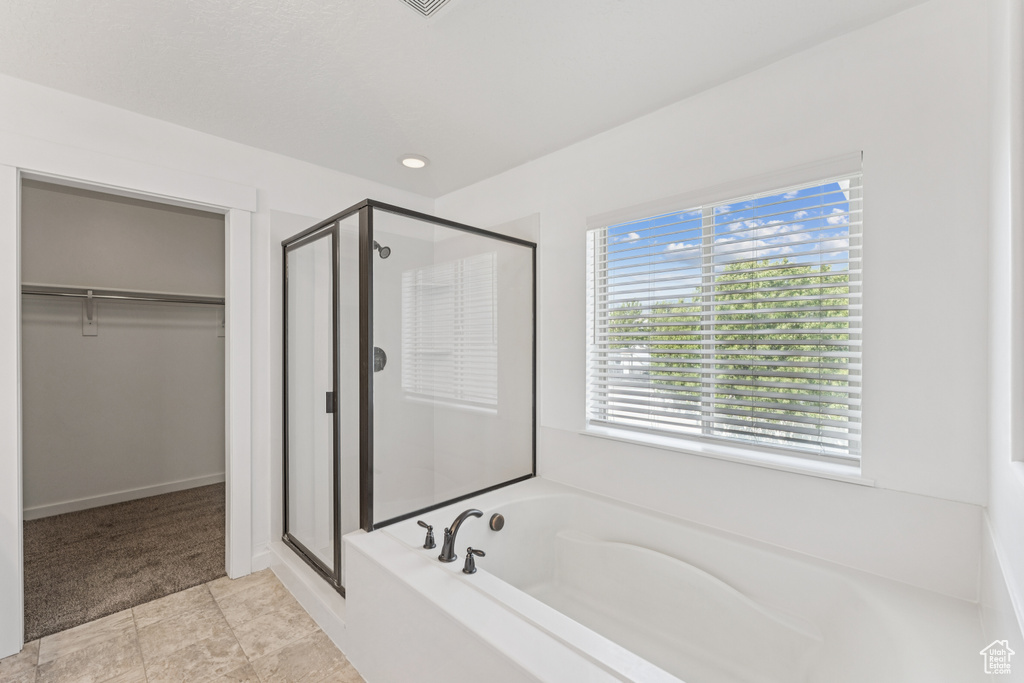 Bathroom with a shower stall, a garden tub, and a walk in closet