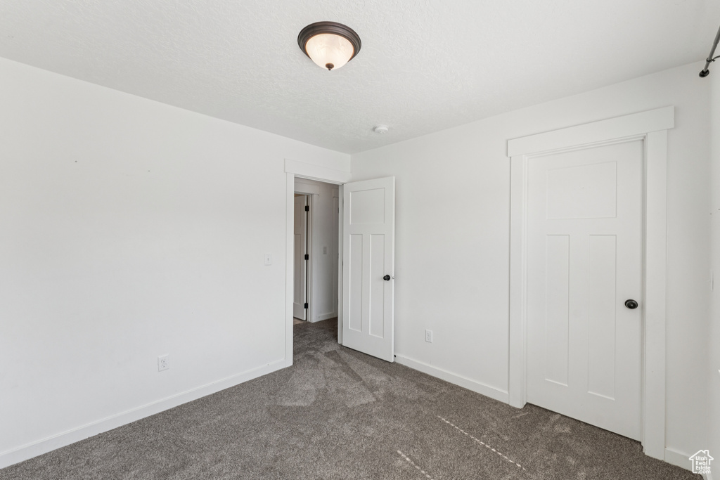 Unfurnished bedroom with carpet and baseboards