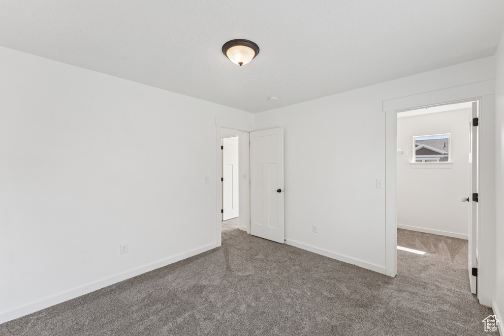 Unfurnished bedroom with carpet floors and a walk in closet