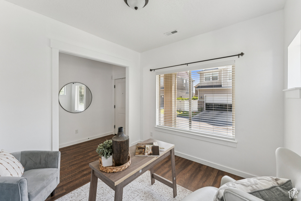 Living area featuring dark wood-style floors and baseboards