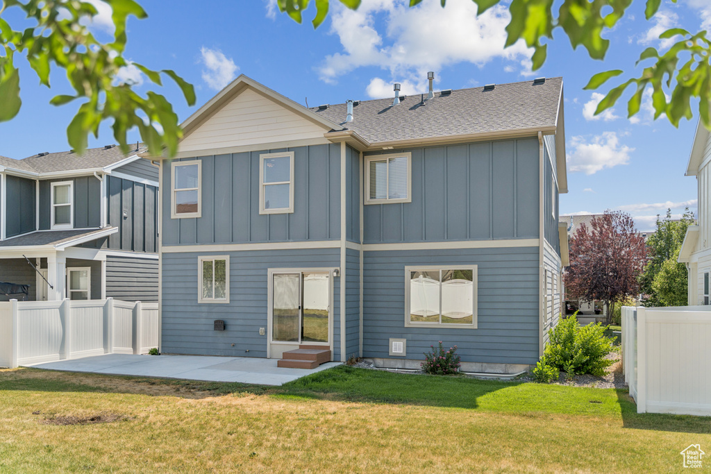 Rear view of property with board and batten siding, a patio, and a shingled roof