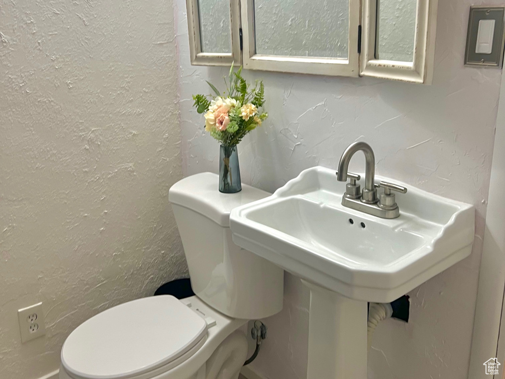 Bathroom featuring wood finished floors and a textured wall