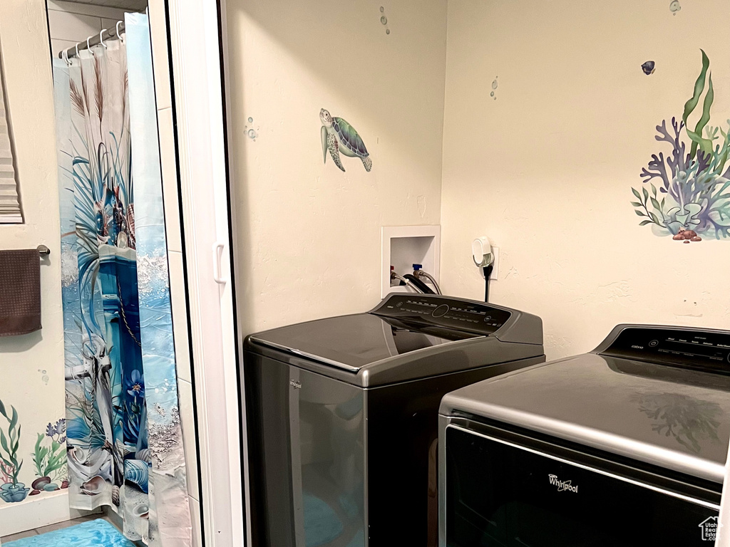 Laundry room with washing machine and clothes dryer and wood finish floors
