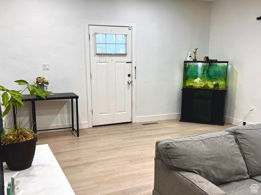 Living room with light wood-style flooring and recessed lighting