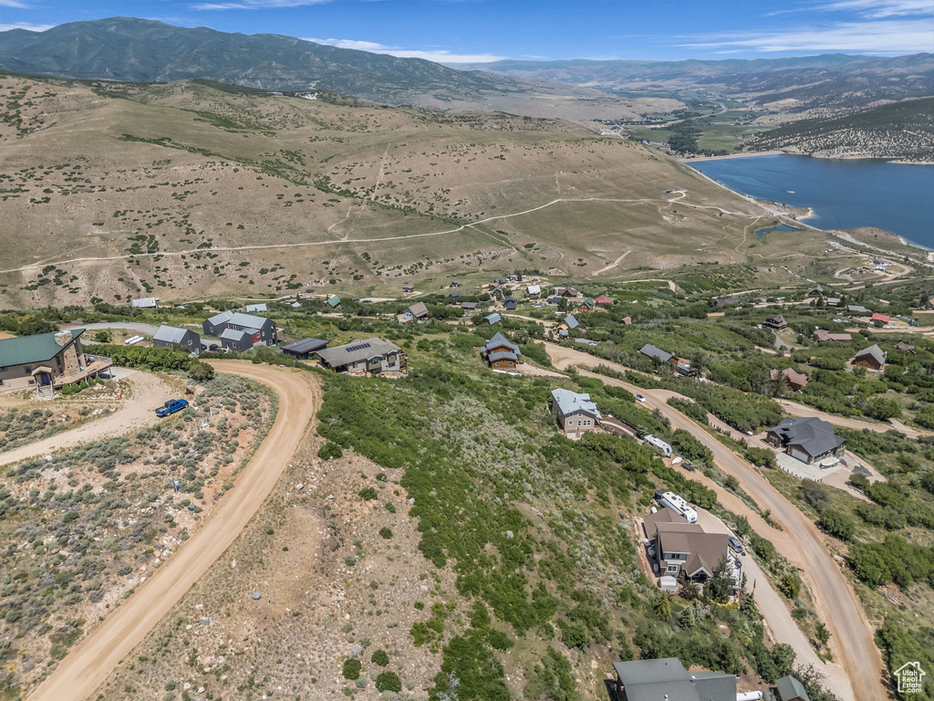 Aerial view of property and surrounding area featuring a water and mountain view