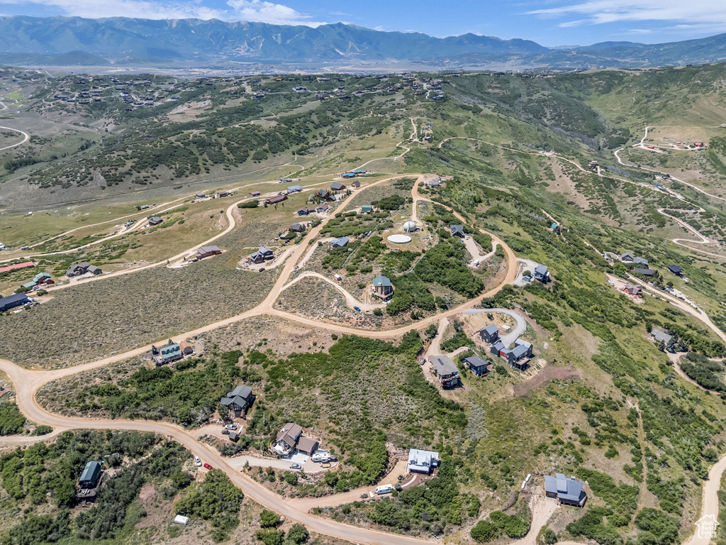 Aerial view of property and surrounding area featuring a mountain backdrop and rural landscape