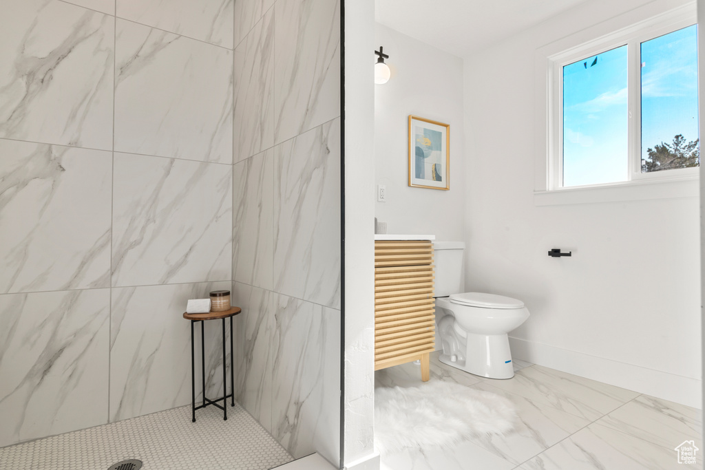 Full bathroom featuring marble look tile flooring and a marble finish shower