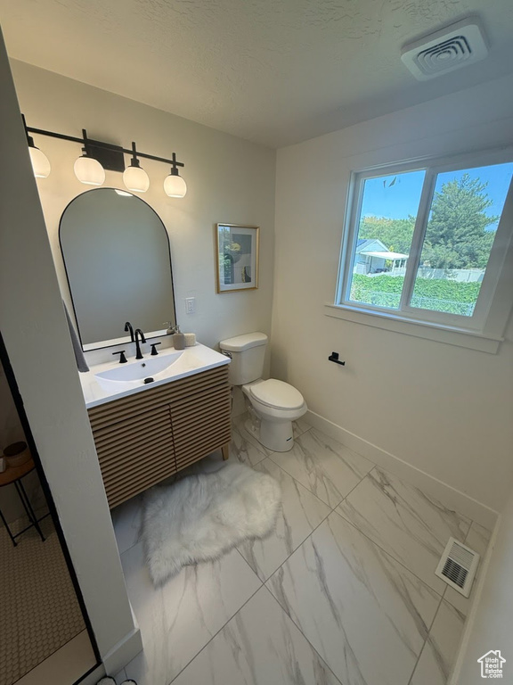 Bathroom with marble look tile flooring and vanity