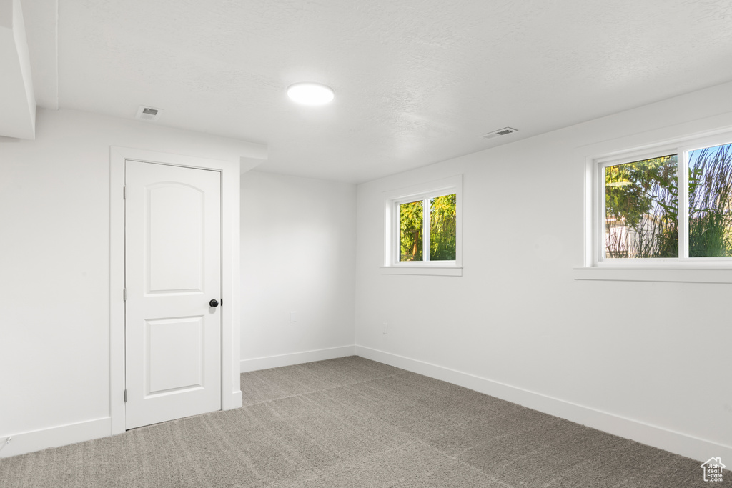 Carpeted spare room with baseboards