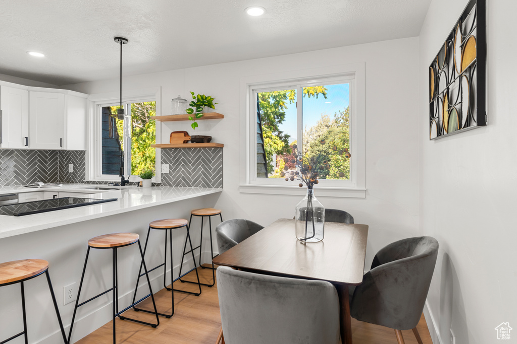 Dining area with plenty of natural light, light wood-style floors, and recessed lighting