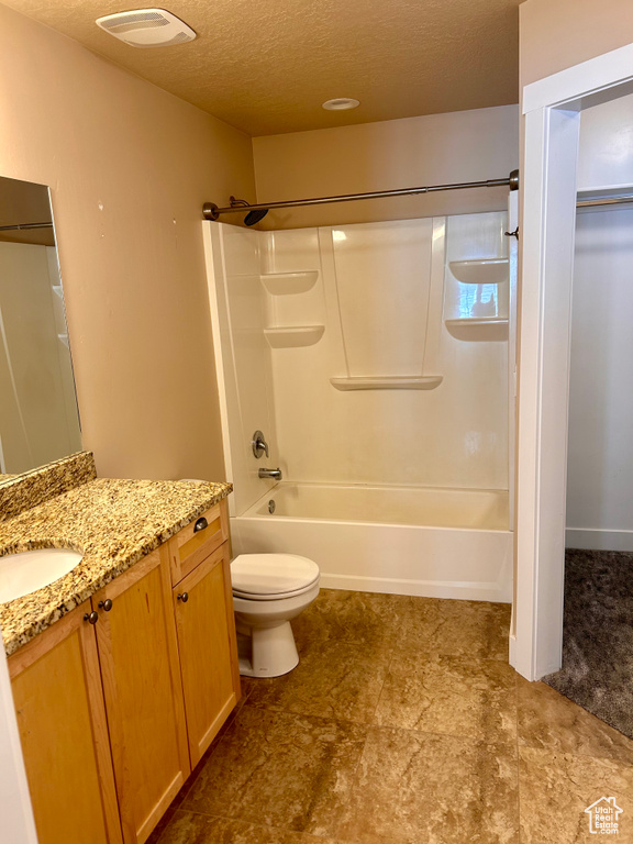 Full bathroom with vanity, tub / shower combination, and a textured ceiling