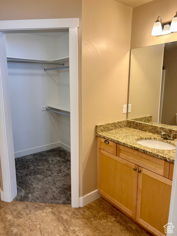 Bathroom featuring vanity and a spacious closet