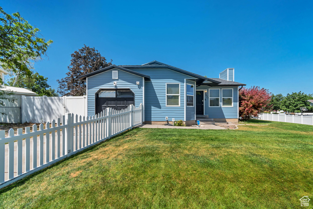View of front facade featuring a garage, a fenced backyard, a chimney, and entry steps