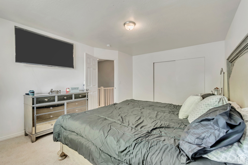 Carpeted bedroom featuring a closet and baseboards