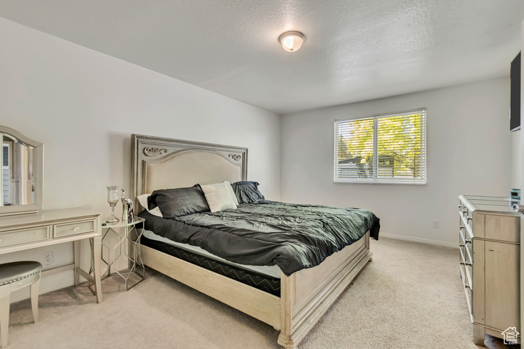 Bedroom featuring light colored carpet and baseboards
