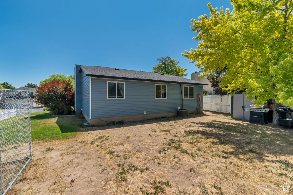 Back of property with a fenced backyard and a chimney